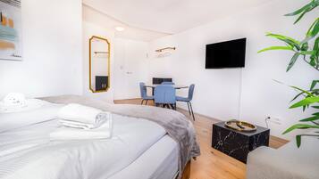 Suite estudio Deluxe, vistas a la ciudad | Zona de estar | Smart TV de 55 pulgadas con canales digitales, suelo radiante