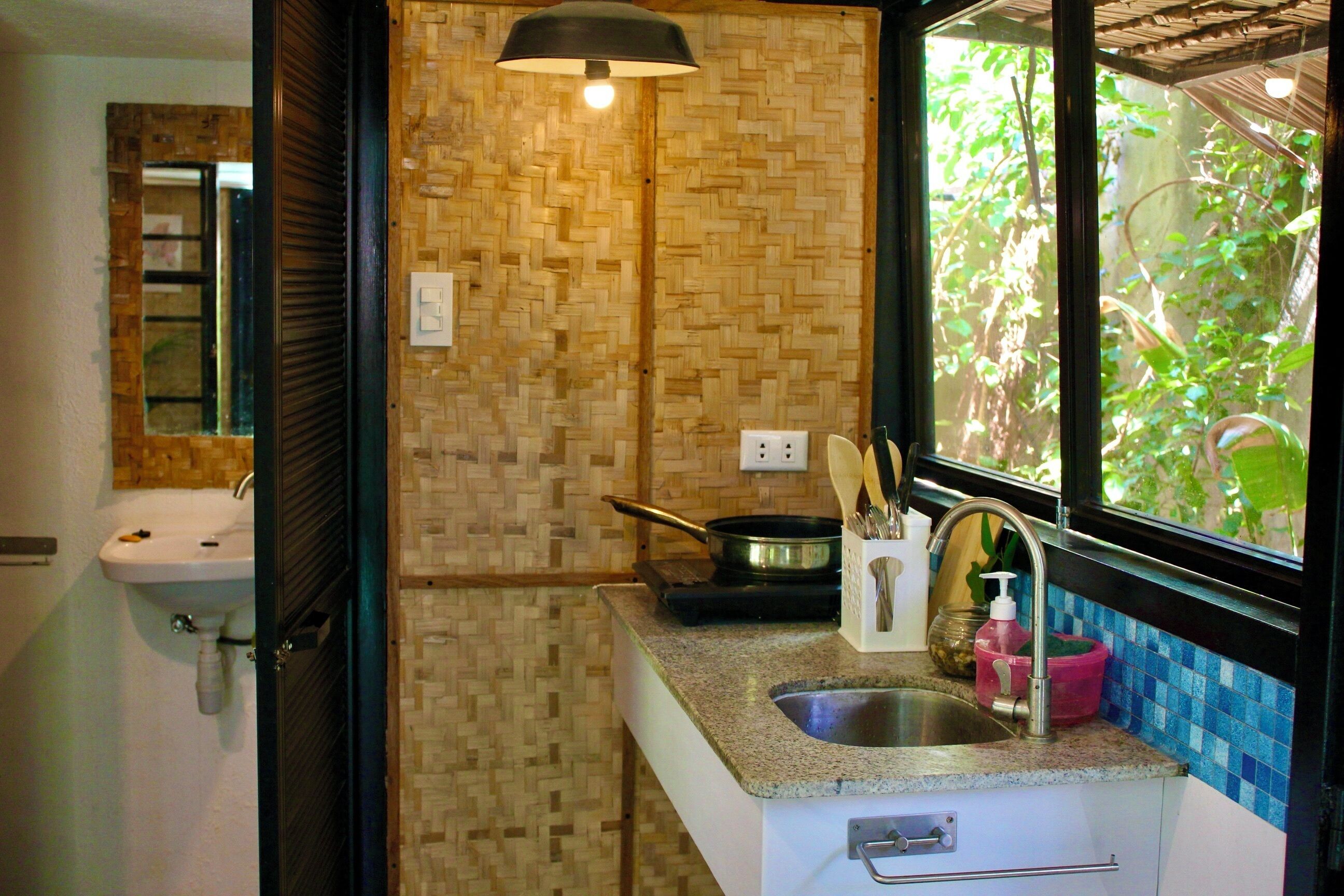 A bathroom with a sink, mirror, and window.
