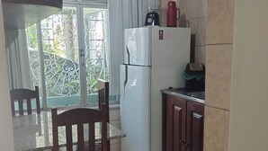Eine Küche mit Kühlschrank, Spüle und einem Essbereich mit Stuhl und Tisch.
