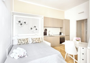 A modern hotel room with a bed, a desk, and a kitchenette. - Old Milan Navigli Family (Milan)
