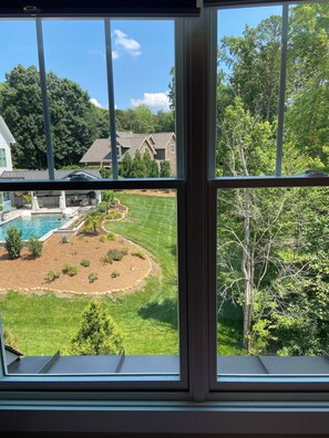 Un jardin arrière aménagé pour une maison d’habitation, avec une piscine, une pelouse et un espace dédié au jardinage.