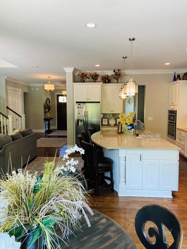 A modern kitchen with white cabinetry, a central island, and pendant lighting. - Lake Norman Area Luxury 6 br, 5 bath, Pool, Hot tub, Pets ok! (Mooresville)