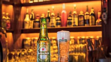 Een bar met een fles Heineken en een glas op de toonbank.