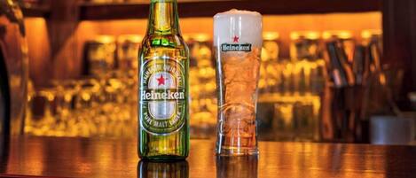 A bar with a bottle of Heineken and a glass on the counter.