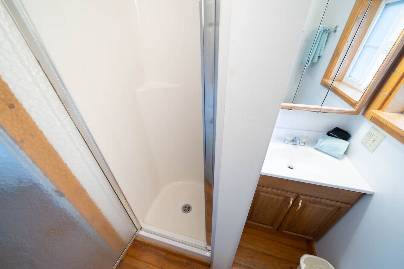 Un baño pequeño con ducha, lavabo y espejo.