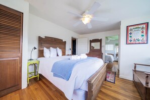 A bedroom with a wooden bed, a ceiling fan, a green nightstand, and a framed picture on the wall. - Vintage Cabin w/ Views in Heart of Estes (Estes Park)