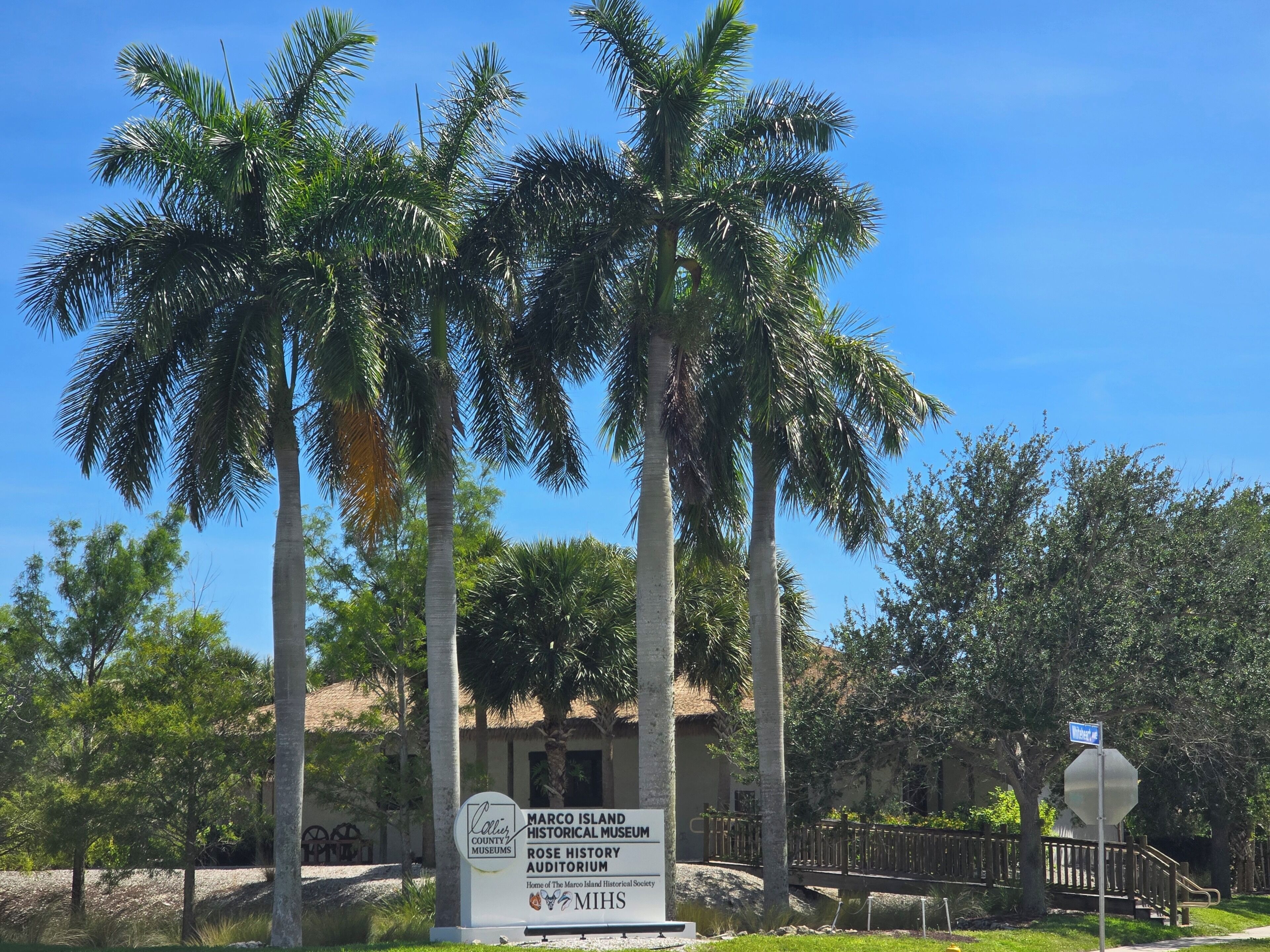 Een bordje voor het Marco Island Historical Museum, met palmbomen op de achtergrond.