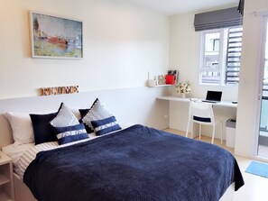 A bedroom with a bed, a desk, and a chair. - Plume Residence Minburi (Bangkok)
