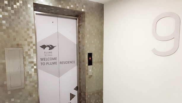 An elevator with a sign reading "Welcome to Plume Residence" and a large number '9' on the wall. - Plume Residence Minburi (Bangkok)
