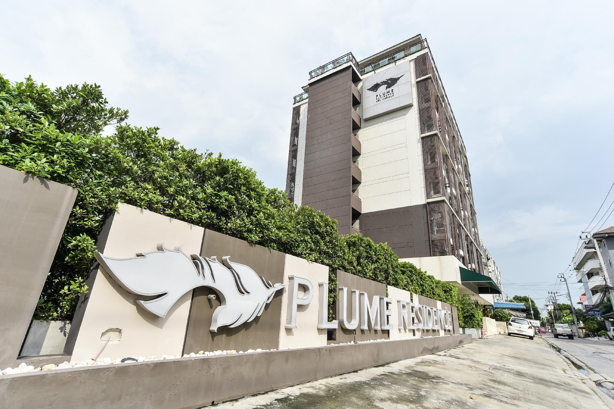 Un edificio con un cartel que dice "PLUME RESIDENCE".