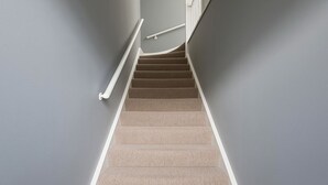 A carpeted staircase with a handrail, leading to a landing. - Beautiful 1 bed flat in Wimbledon (London)