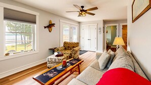 A living room with a sofa, a chair, a table, and a ceiling fan. - Southbrook Cottage-Waterfront*Pet Friendly*A/C*Washer/Dryer (Greenville)