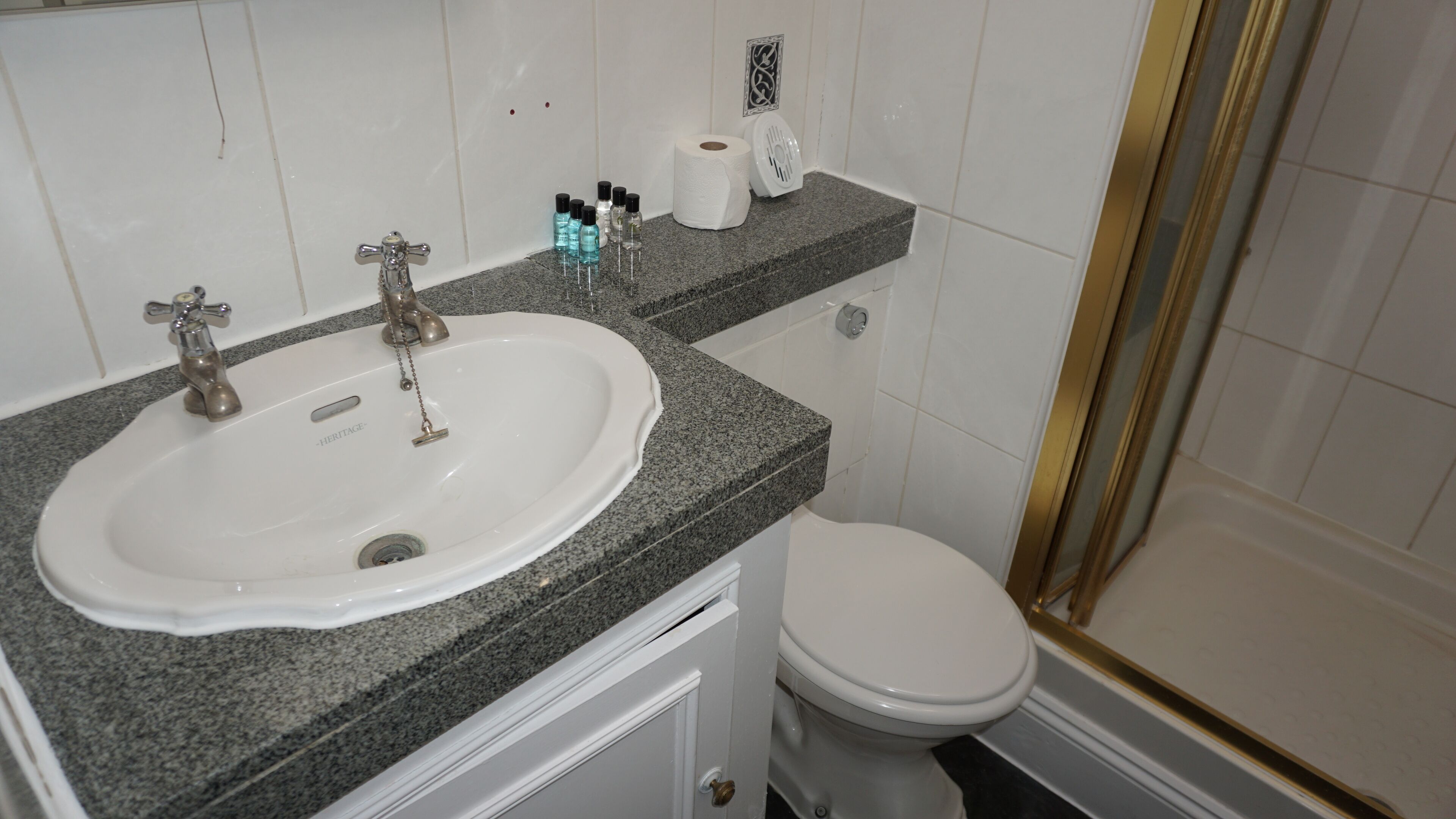 A bathroom with a white sink, a toilet, and a shower area.