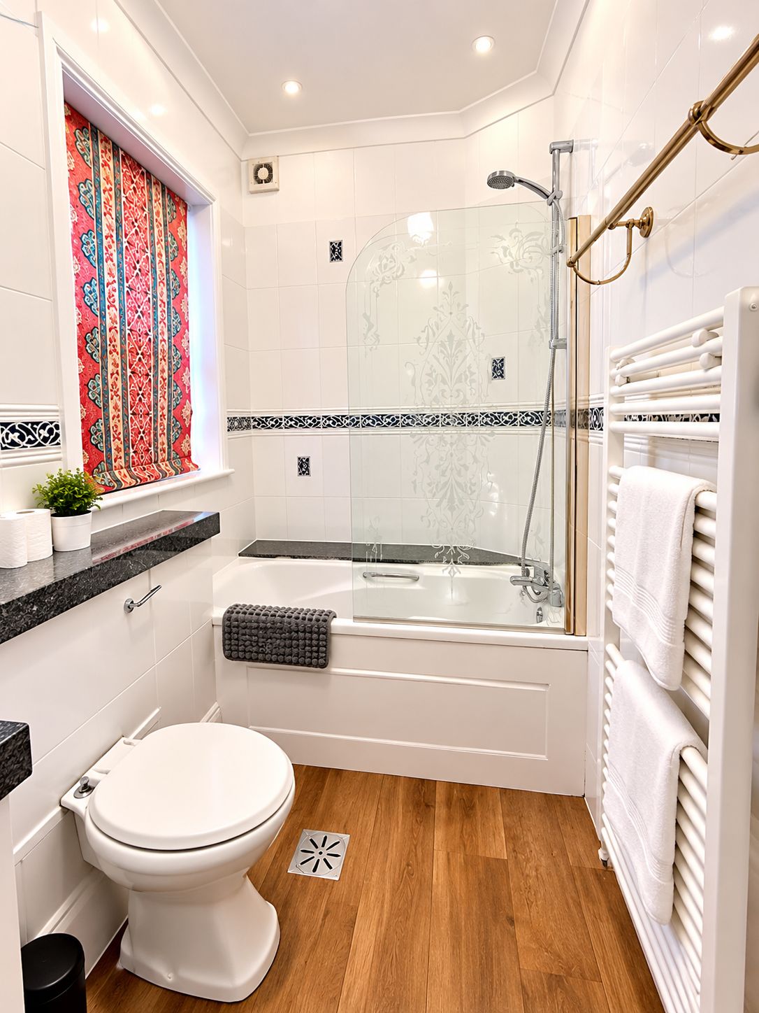 Ein modernes Badezimmer mit einer Duschkabine, einer weißen Badewanne und einer Toilette.