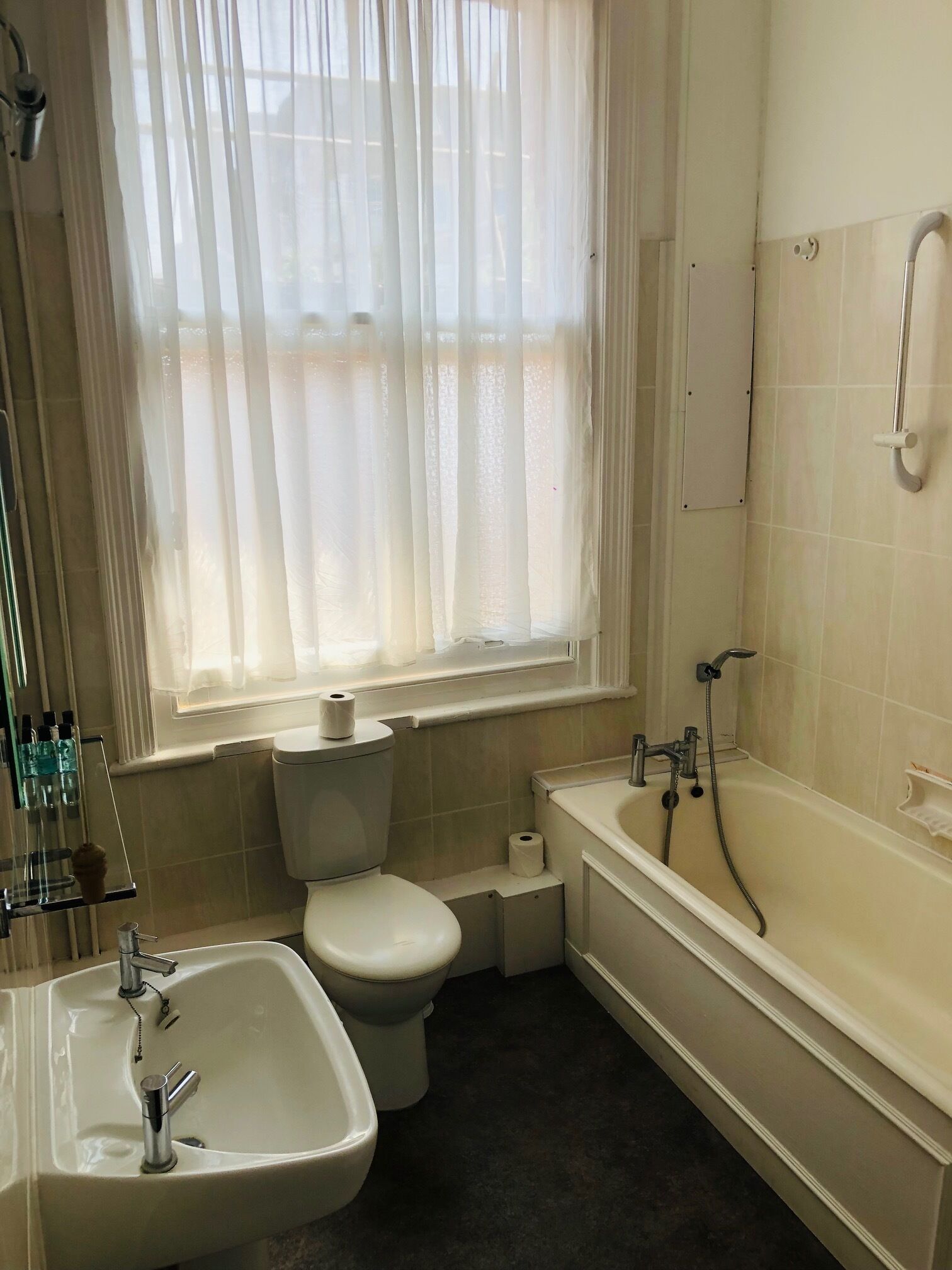 Un baño con inodoro, lavamanos y bañera.