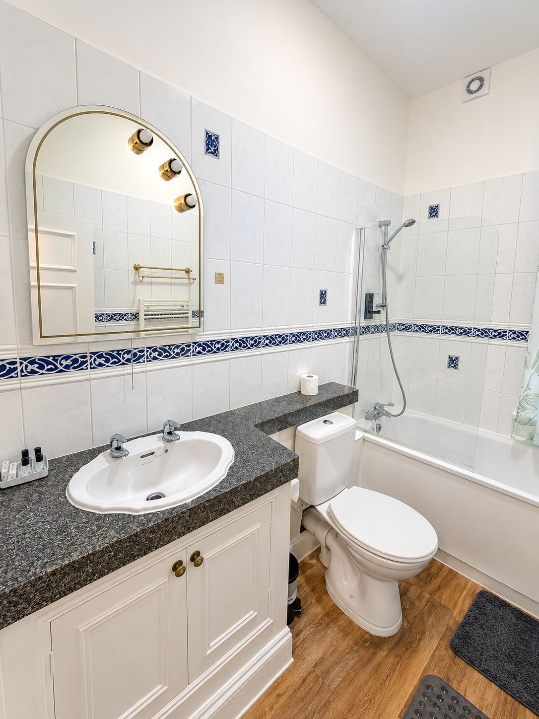 A bathroom with a white sink, a toilet, and a shower.