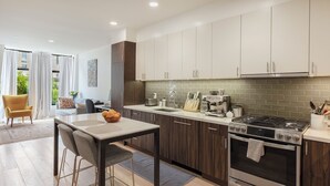A modern kitchen with dark wooden cabinets, a stainless steel stove, and a dining area with a table and chairs. - Charming 1-bedroom condo in fabulous San Francisco with WiFi, AC fully furnished (San Francisco)