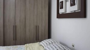 A bedroom with a bed, a wardrobe, and a framed picture on the wall. - WR7 Hostel (Sao Bernardo do Campo)