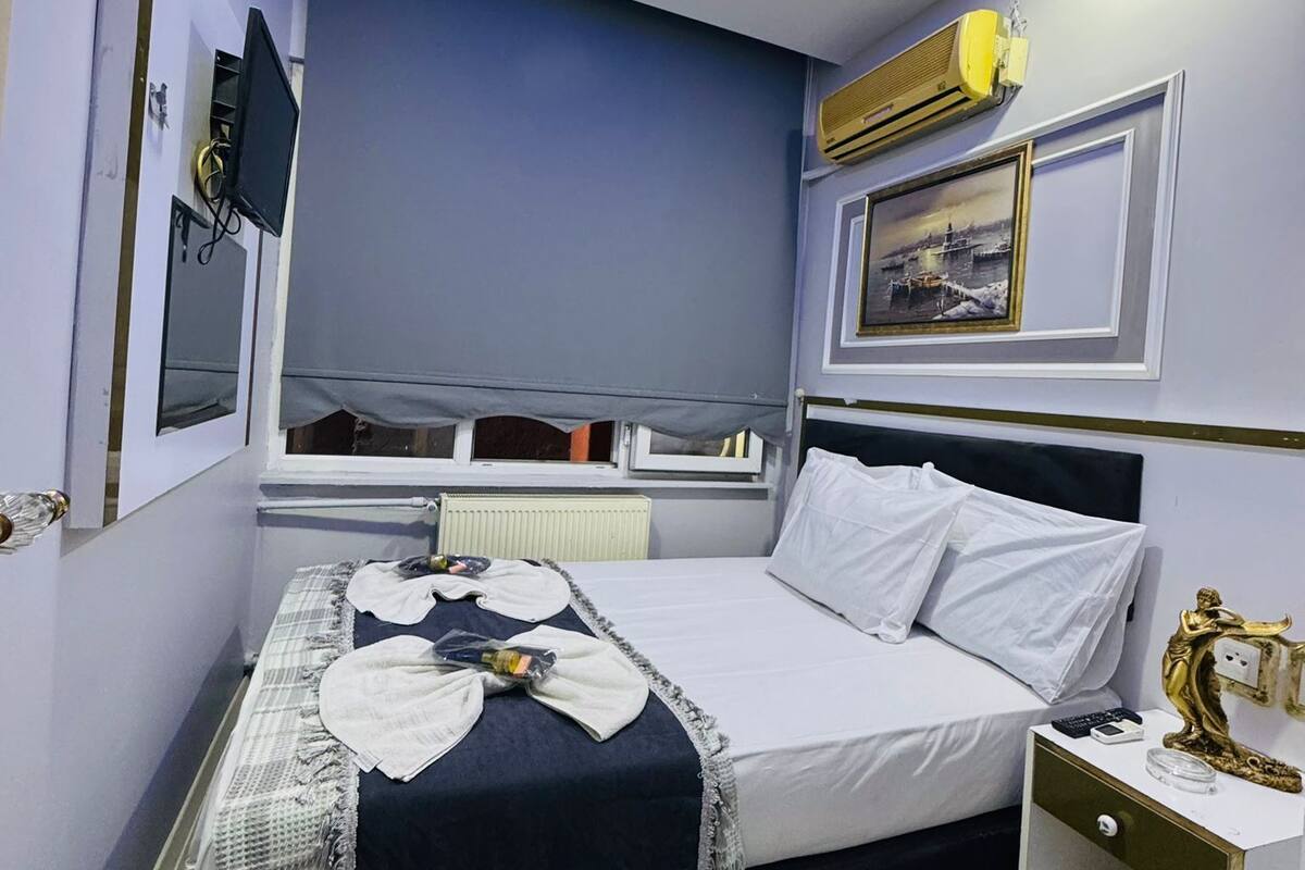 A modern bedroom with a bed, bedside table, and a mounted TV.