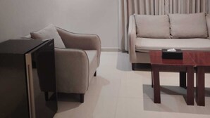 A modern living room with a sofa, a coffee table, and a TV. - Rama Dubai Hotel Suites 1 (Riyadh)