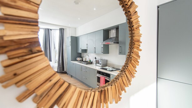 Una cocina moderna con gabinetes grises, un microondas y una estufa.