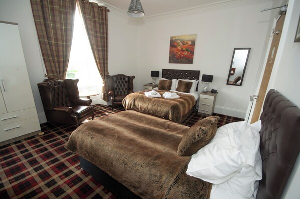 A hotel room with a large bed, a chair, a desk, and a painting on the wall. - Haughton Arms Hotel (Alford)