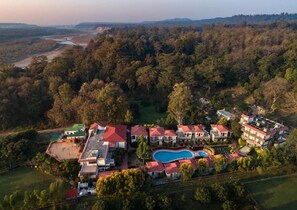 Luchtbeeld van een resort met meerdere gebouwen, een zwembad en een golfbaan.