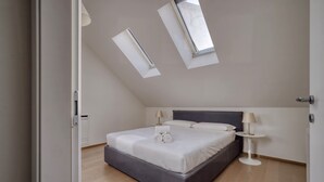 Una camera da letto con un letto, due comodini, una finestra e una porta.