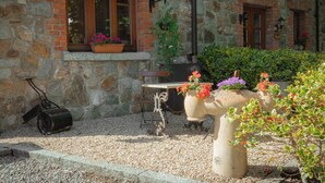 A stone building with a window and a door, a potted plant, and a decorative metal sculpture. - Charming 1-bedroom cottage in Rathdrum with WiFi (Rathdrum)