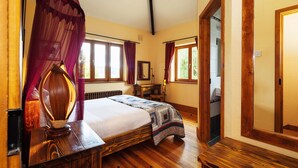 A bedroom with a wooden bed, a bedside table, a lamp, and a window with curtains. - Charming 1-bedroom cottage in Rathdrum with WiFi (Rathdrum)