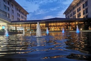 Un patio de hotel con una fuente y una superficie acuática reflectante.