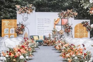 Un pasillo nupcial decorado con arreglos florales y un arco de madera.