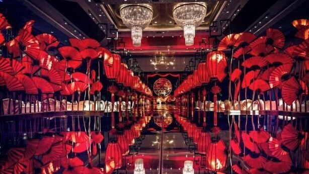 A hotel lobby with a reflective floor and red umbrellas as decor. - Qisheng Internation Hotel (Zibo)