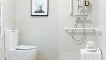 Een moderne badkamer met douche, toilet en een inlijsting foto aan de muur.