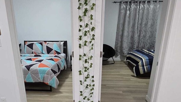 Een kamer met een bed, een stoel en een wand versierd met planten.