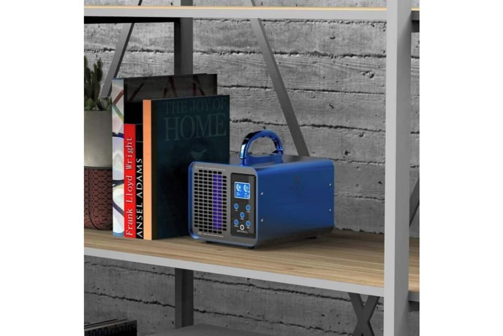 A shelf with books and a blue portable speaker.