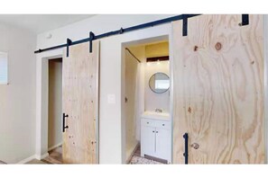 A room with a sliding door, a white cabinet, and a mirror.