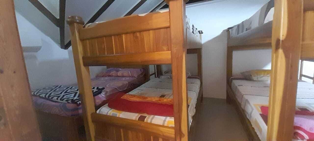 Dormitorio con literas de madera y techo inclinado.