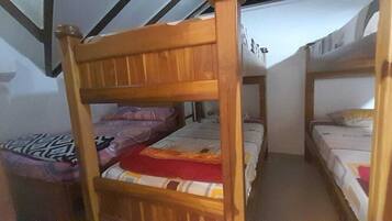 Dormitorio con literas de madera y techo inclinado.