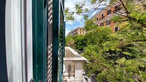Vista desde una ventana que da a una calle con edificios y árboles.