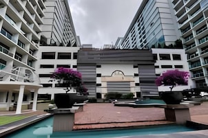 Un hotel moderno con un patio central, varias plantas y zona de piscina.