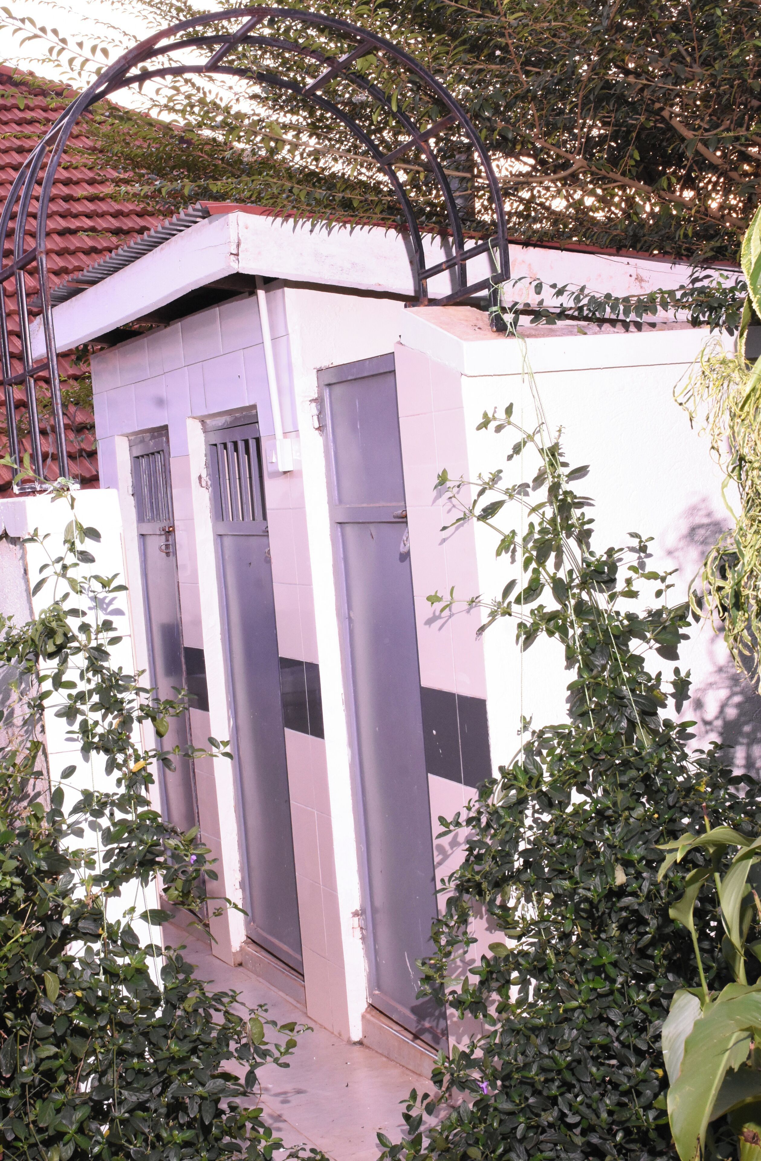 Un edificio con tres ventanas verticales y una estructura metálica en la parte superior.