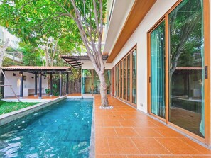 A modern house with a swimming pool, a covered patio, and large glass doors. -  Serava Pet-Friendly Pool Villa Huahin (Hua Hin)