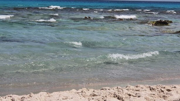A beach with clear turquoise water, visible rocks, and sandy shore. - A pleasant ground floor 5 minutes' walk from the beach (Hergla)