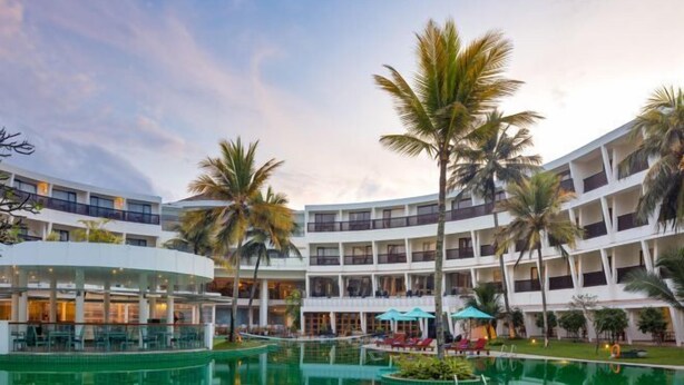 A hotel with multiple floors, a central courtyard with a swimming pool, and palm trees. - The Eden Beruwala (Beruwala)