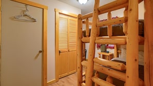 A room with a wooden ladder, a closet with sliding doors, and a bed with pillows.