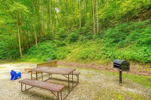 Ein Picknicktisch und Bänke in einem bewaldeten Gebiet mit einem Briefkasten.