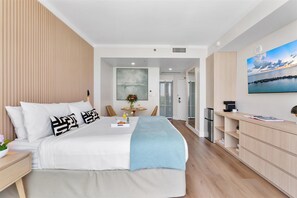 A modern bedroom with a bed, bedside table, and a TV on the wall.