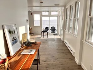 A spacious room with a wooden floor, large windows, and a view of the city.