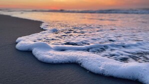 A beach with waves gently lapping onto the shore.